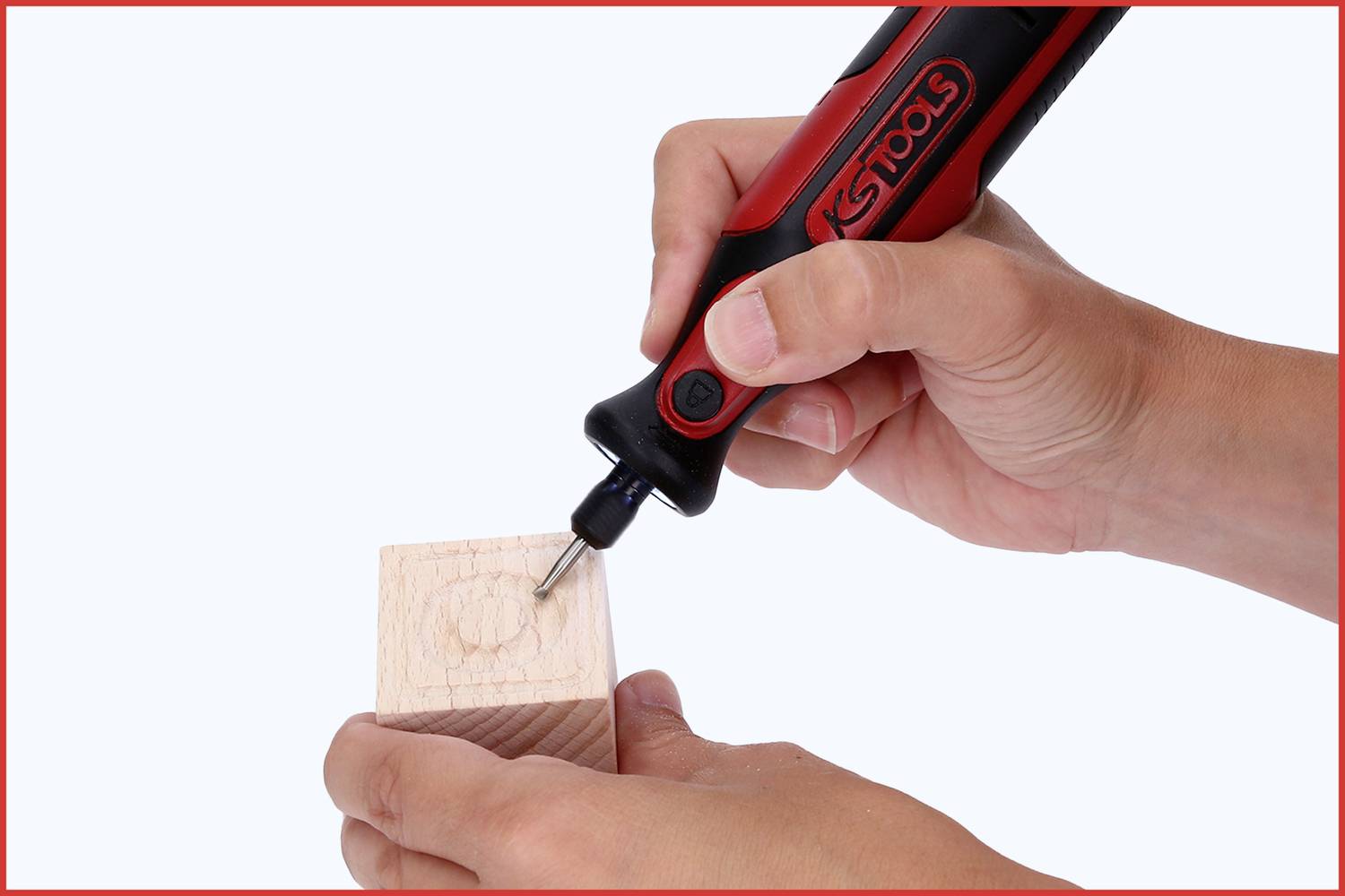 Eine Hand hält einen elektrischen Schraubenzieher an einem Holzblock. Der Schraubenzieher hat ein rotes und schwarzes Design.