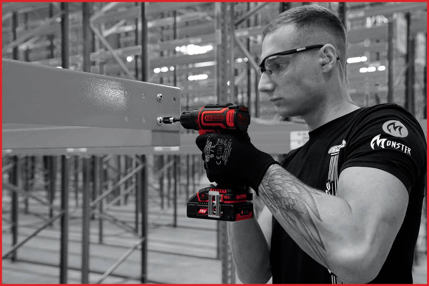 Eine Person mit Schutzbrille verwendet einen Akkuschrauber, um Metallregale in einem Lagerhaus zu montieren.