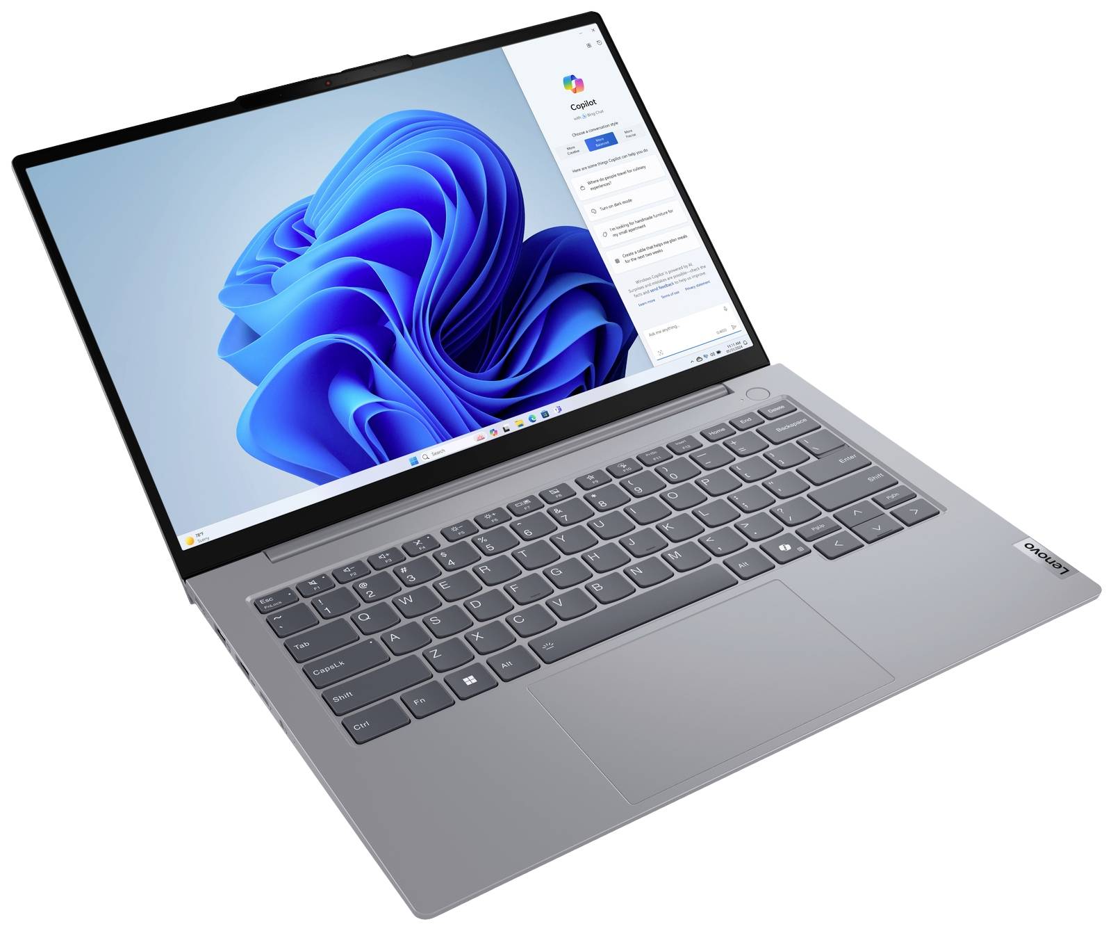 Ein silberner Laptop mit Windows-Betriebssystem zeigt ein blaues Hintergrundbild auf dem Bildschirm. Die Tastatur ist gut sichtbar.