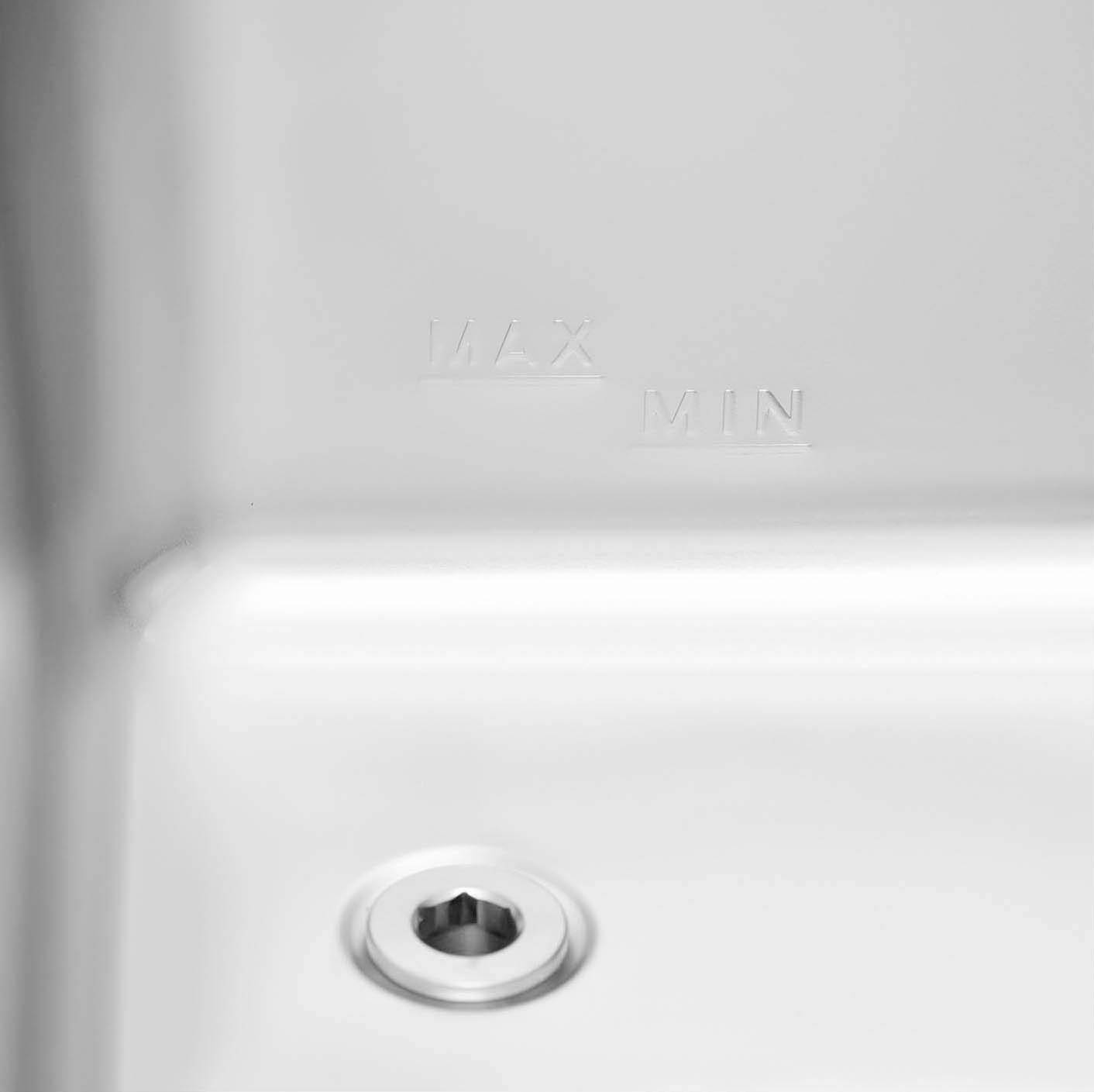 Nahaufnahme eines Waschbeckens mit einem Abfluss und den Markierungen 'MAX' und 'MIN'.