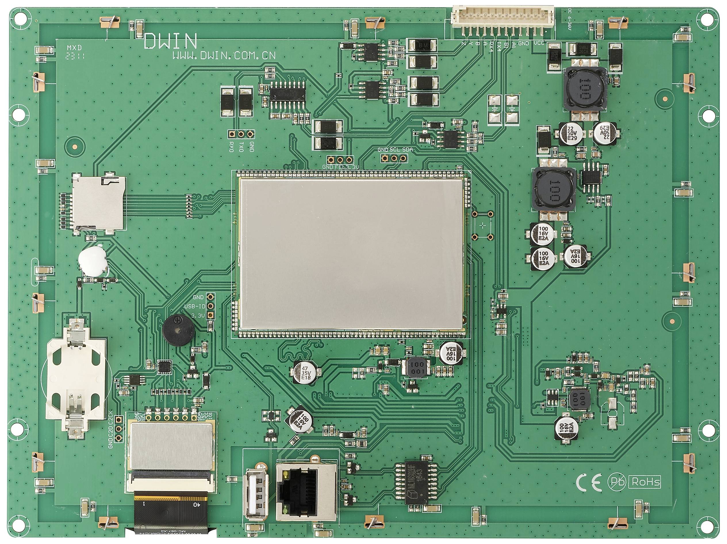 Eine grüne Platine mit verschiedenen elektronischen Komponenten und Anschlüssen, einschließlich eines zentralen Displays.