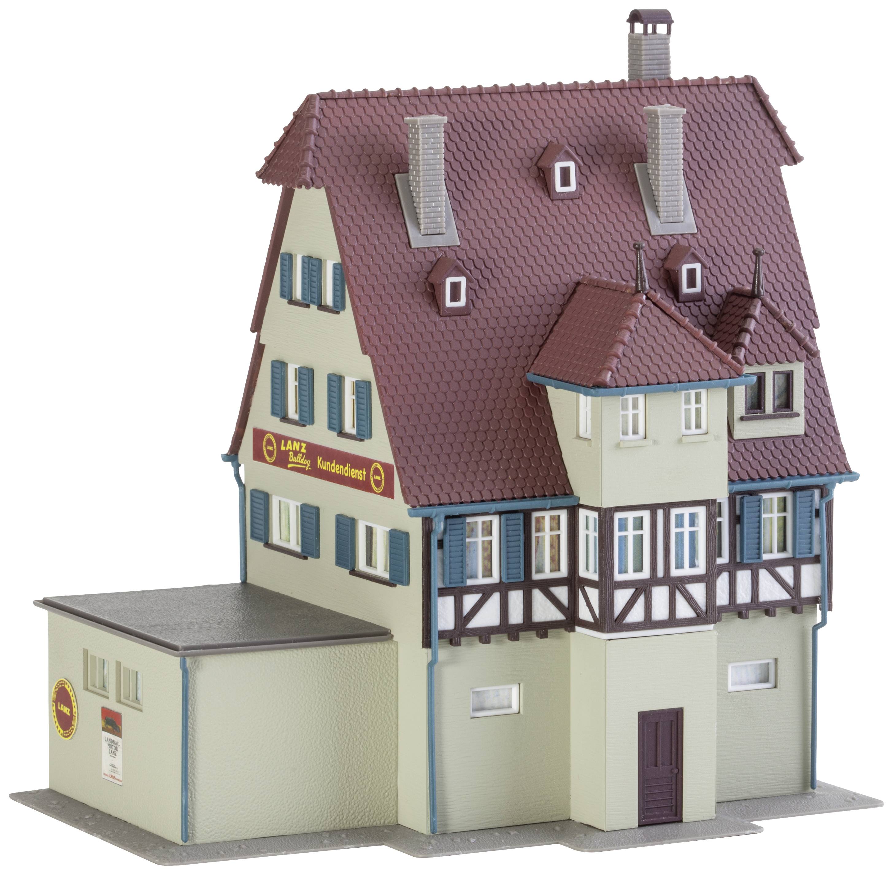 Ein Modell eines zweistöckigen deutschen Fachwerkhauses mit mehreren Dachgauben und einem angrenzenden Flachdachanbau.