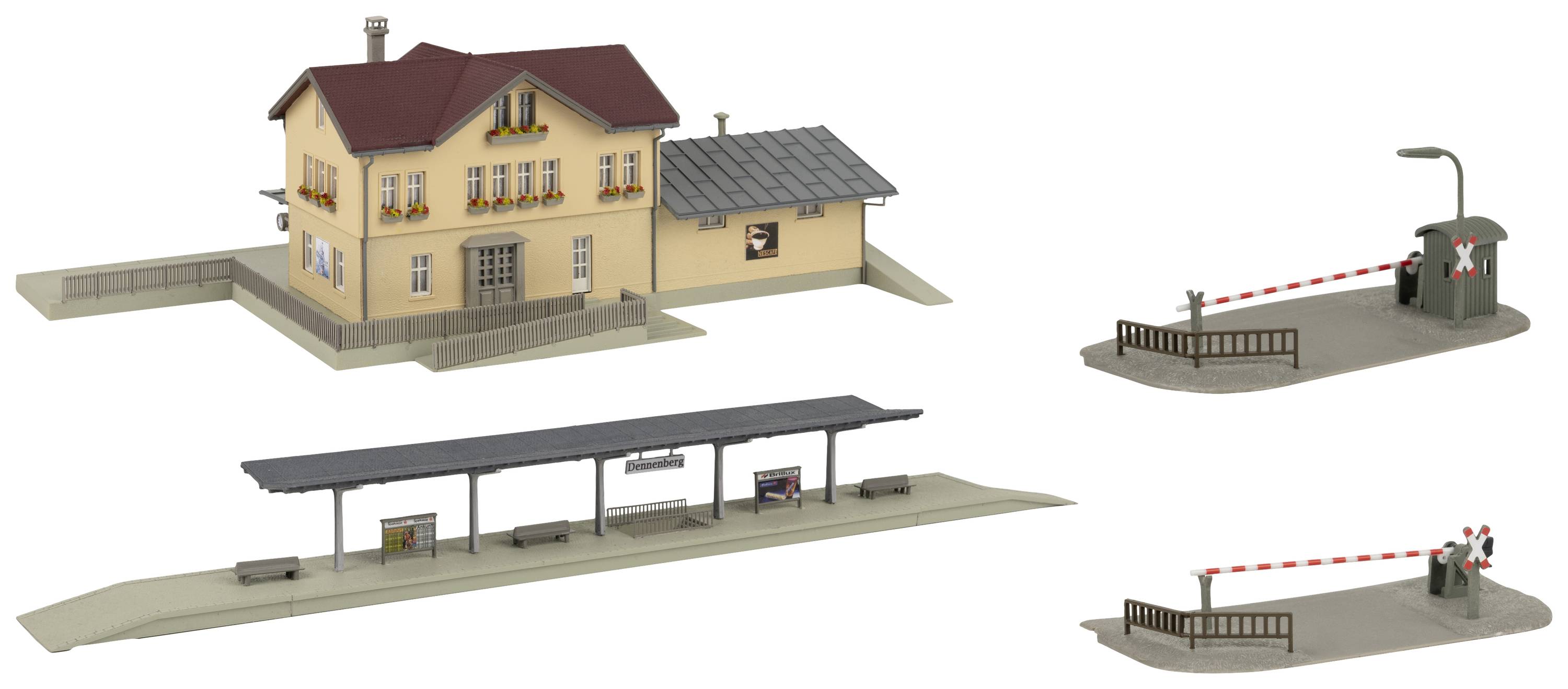 Modell eines kleinen Bahnhofs mit Hauptgebäude, Bahnsteig und zwei Schranken. Hauptgebäude in gelb-braun mit rotem Dach.
