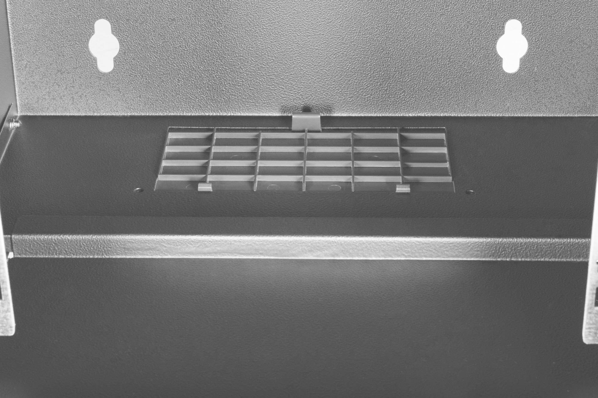 Metallischer Lüftungsschlitz eingekapselt von glatter Oberfläche und zwei runden Ausstanzungen oben sichtbar.