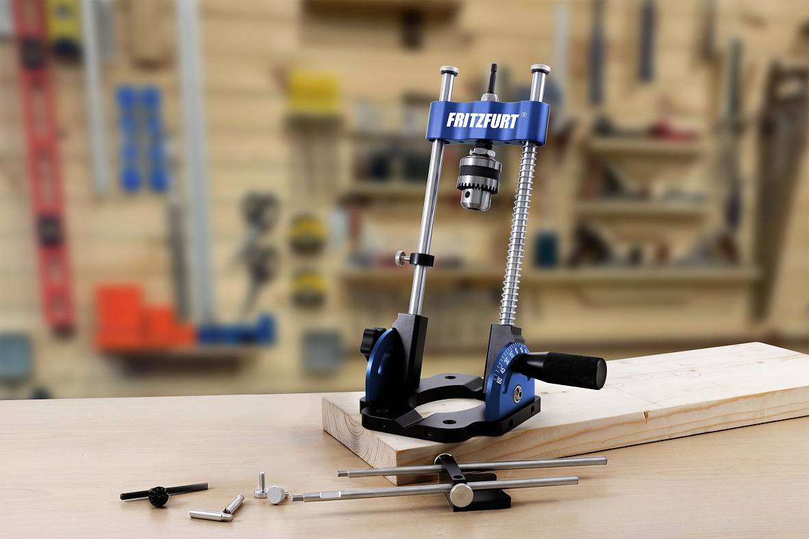 Schraubstock und Zubehör auf Werkbank, unscharfer Hintergrund zeigt Werkstattregale.