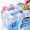 'Packung mit 15 Flaschen Nestlé Pure Life Wasser. Eine Hand benutzt ein grünes Werkzeug, um die Plastikverpackung zu öffnen.'