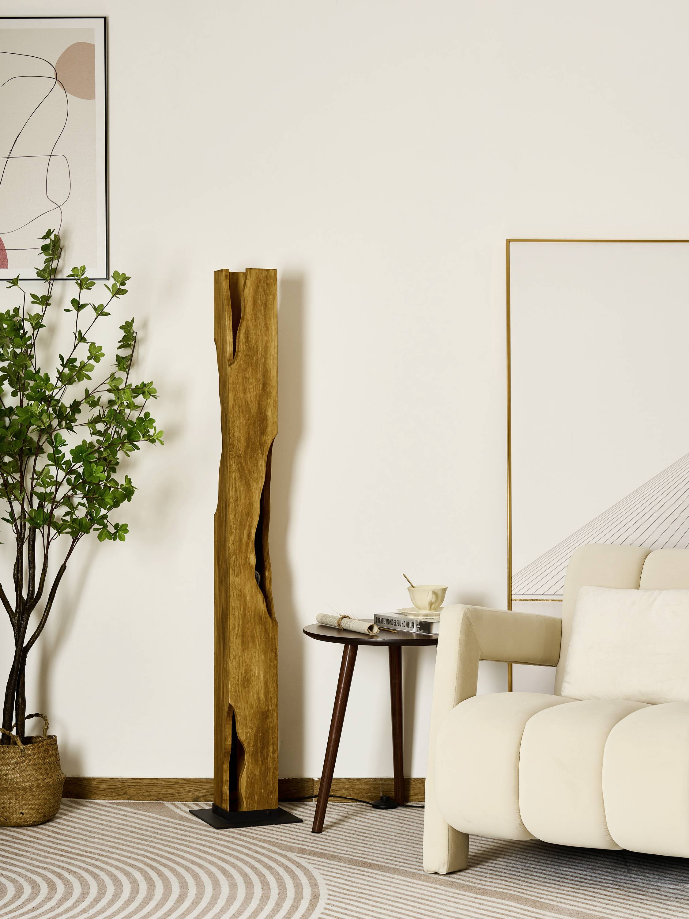 Ein modernes Wohnzimmer mit einem weißen Sofa, einem runden Tisch und einer großen Holzskulptur. Pflanzen und abstrakte Kunst schmücken den Raum.