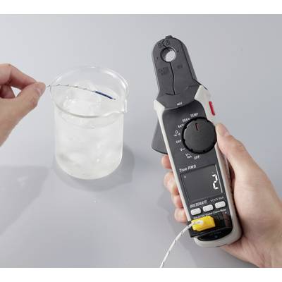 Eine Person verwendet ein digitales Thermometer, um die Temperatur der Flüssigkeit in einem Becherglas zu messen, das mit Eiswasser auf einer grauen Oberfläche gefüllt ist.