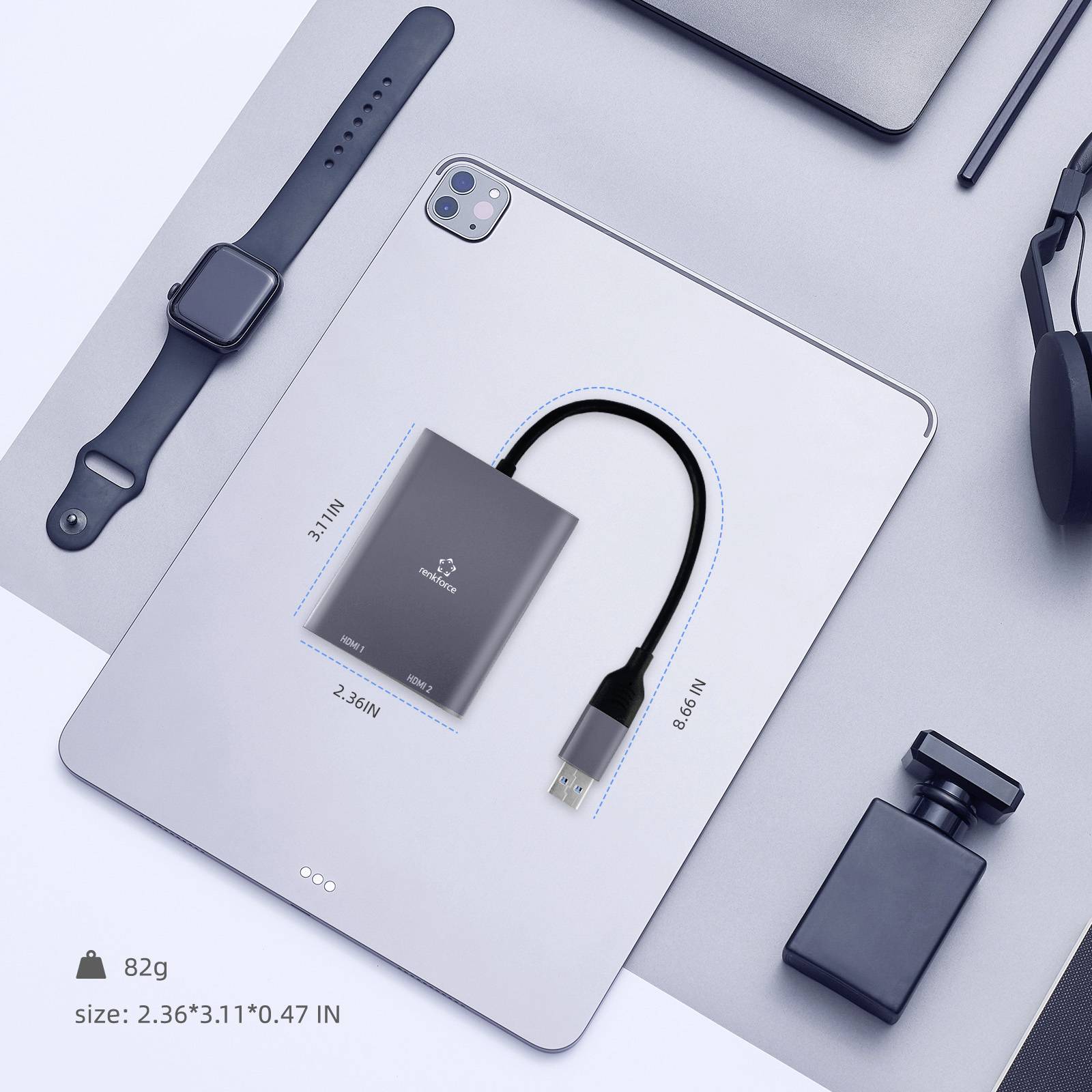 Eine Tablette, eine Smartwatch, eine Maus und Technologie-Zubehör auf einer grauen Oberfläche. Hervorgehoben ist ein kleines, quadratisches USB-Gerät mit aufgelisteten Abmessungen und Gewicht.