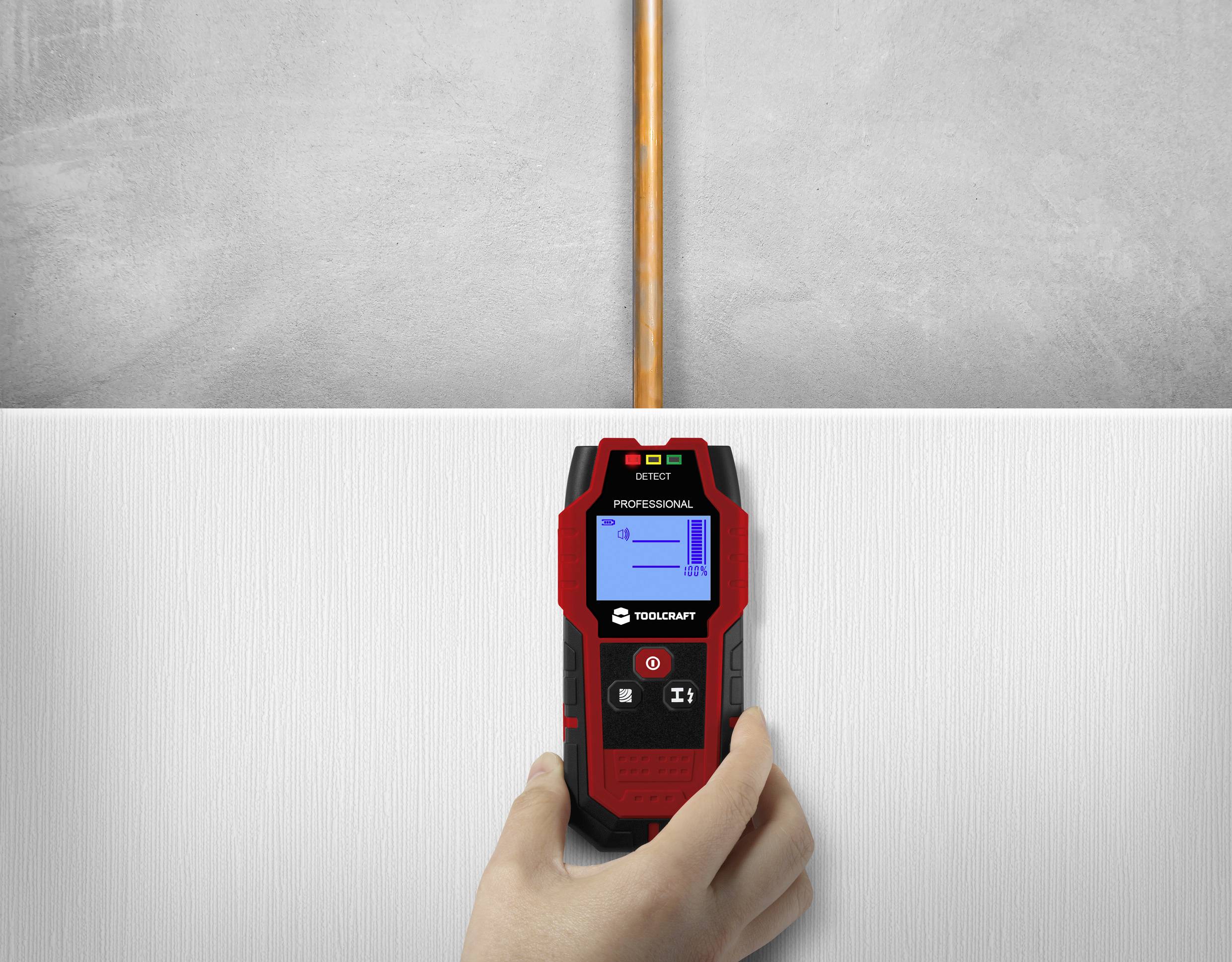 Ein Handwerker verwendet ein elektronisches Ortungsgerät an einer Wand, um die Position eines Kupferrohrs zu bestimmen.