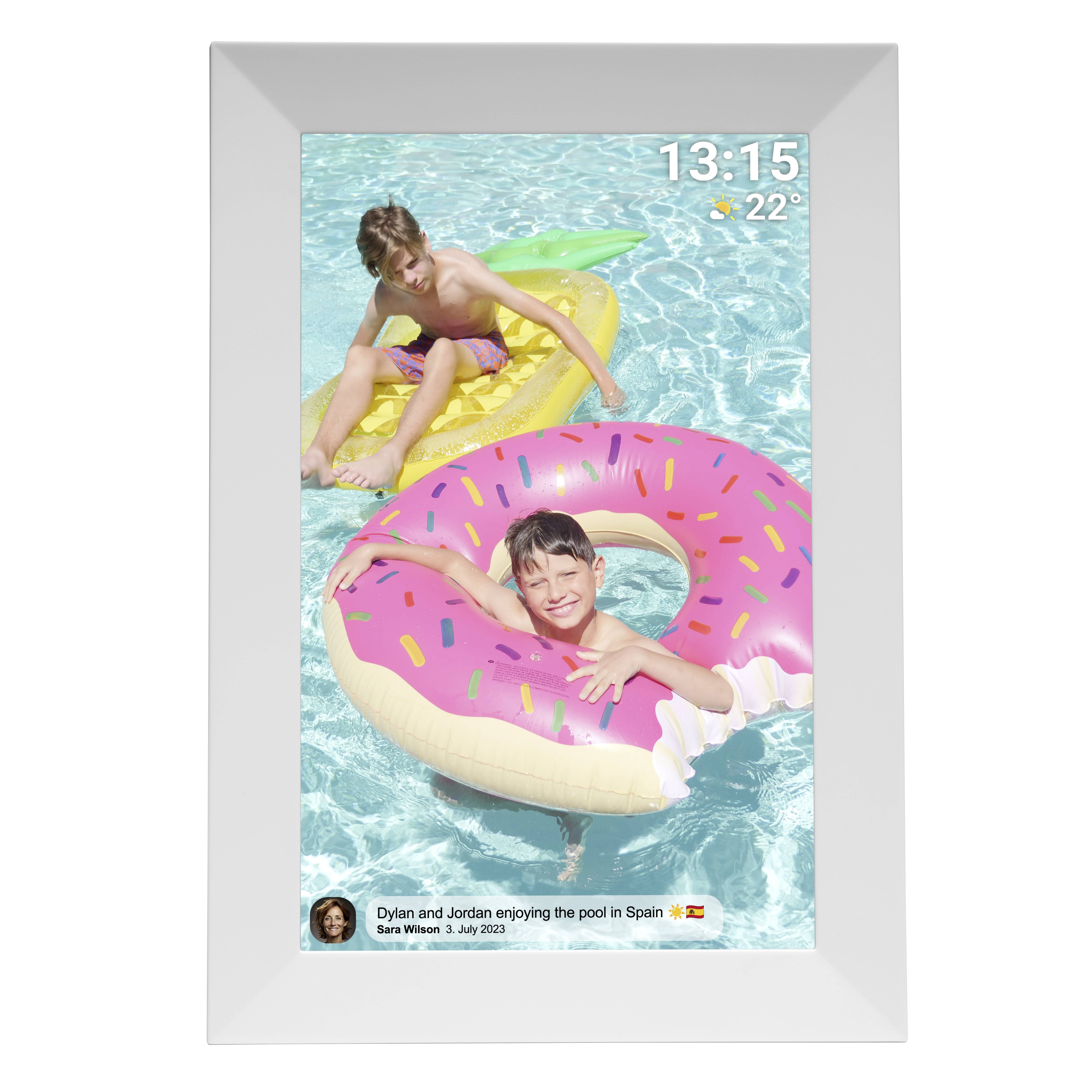 Zwei Kinder spielen auf aufblasbaren Schwimmringen im Pool. Oben rechts die Uhrzeit '13:15' und Temperatur '22°C'. Unten steht 'Dylan und Jordan genießen den Pool in Spanien'.