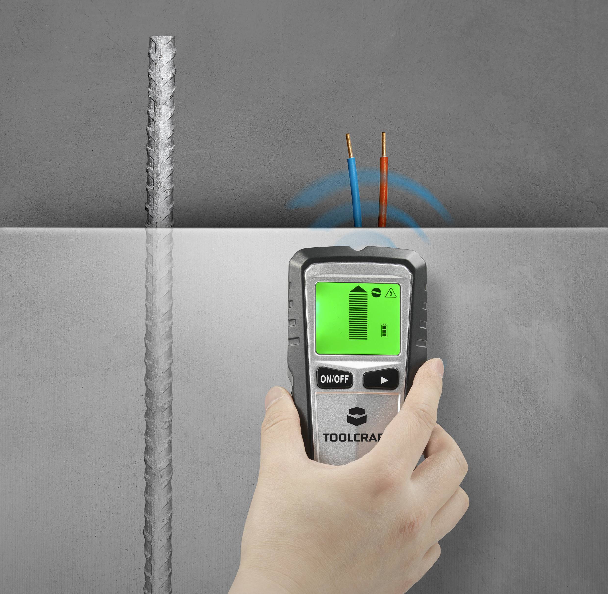 Eine Hand hält ein Gerät zur Kabelsuche an einer Wand. Auf dem Bildschirm des Geräts zeigen Symbole die Kabelposition und Warnhinweise an.