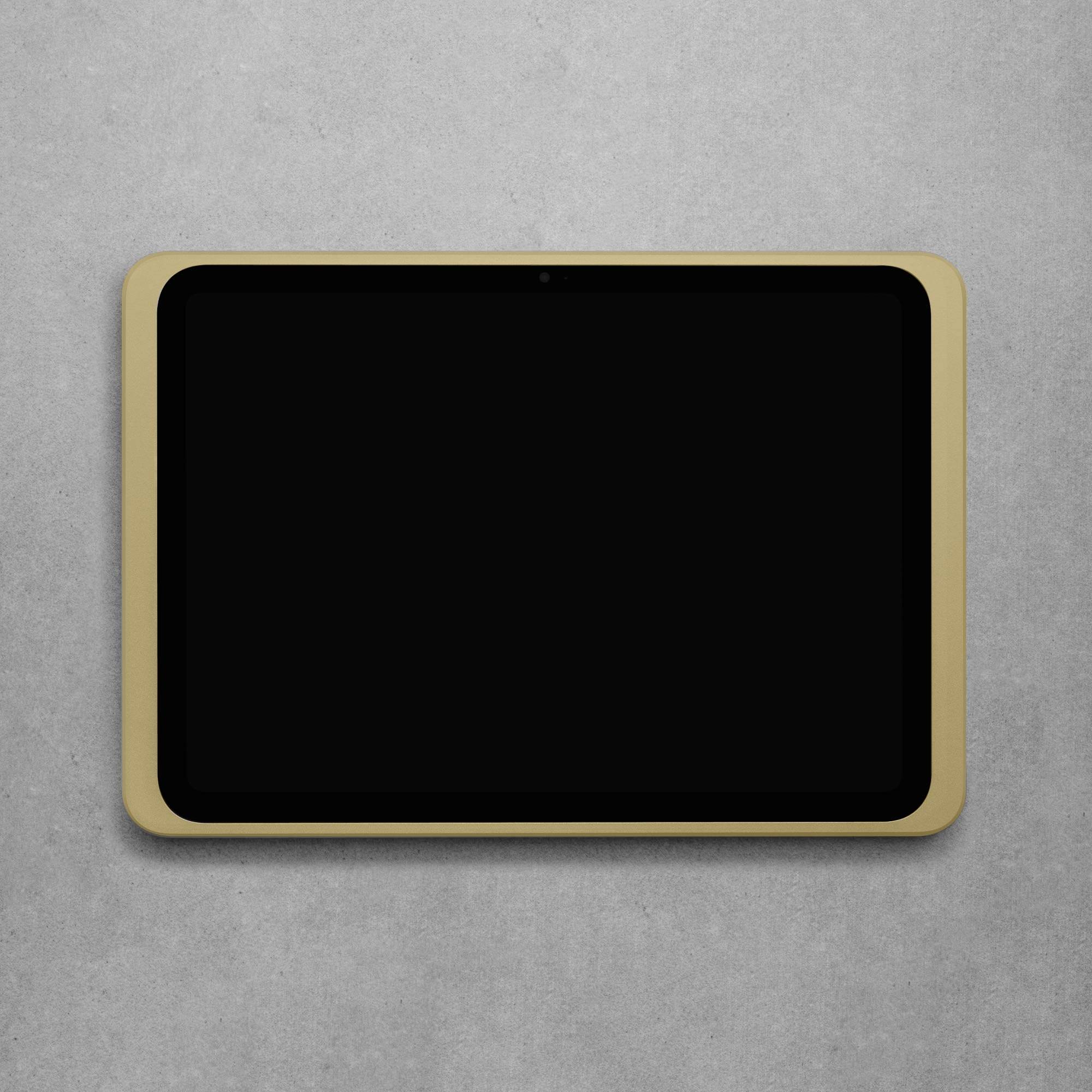 Ein Tablet mit schwarzem Bildschirm und goldener Umrandung liegt auf einer grauen Oberfläche.