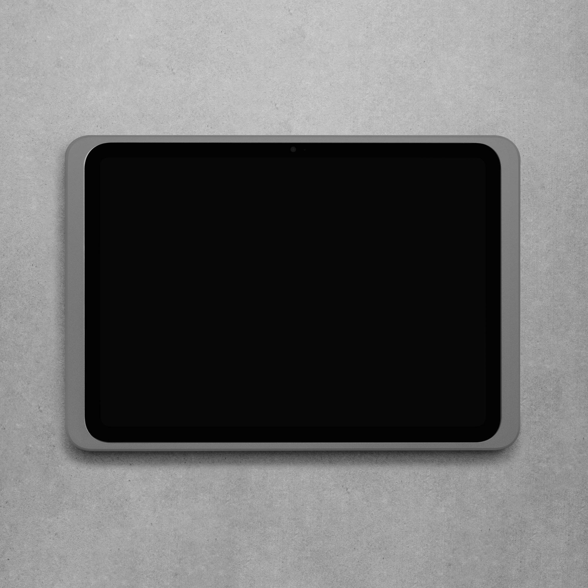 Ein Tablet mit schwarzem Bildschirm liegt flach auf einer grauen Oberfläche.