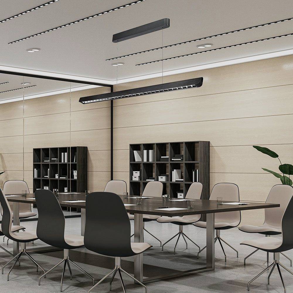 Ein moderner Konferenzraum mit einem großen Tisch, umgeben von zehn Stühlen. An den Wänden sind Regale mit Büchern und Pflanzen.
