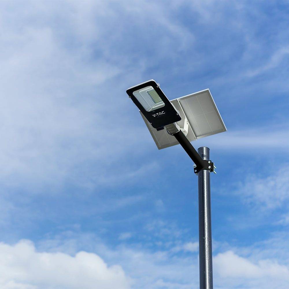 Eine Solar-Straßenlaterne mit Paneel vor einem klaren blauen Himmel. Sie symbolisiert umweltfreundliche Energiequellen.
