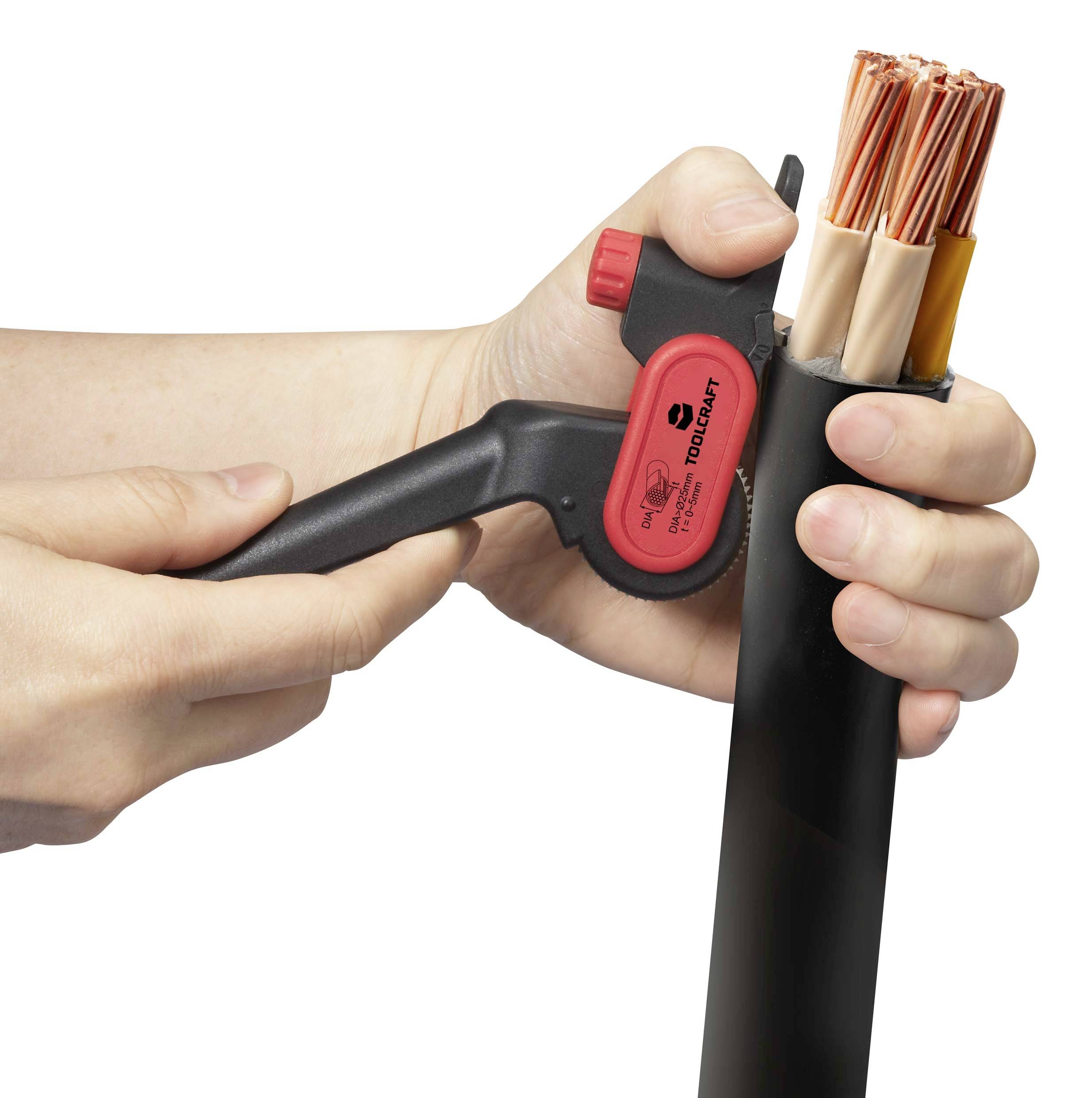 Person hält ein Abisolierwerkzeug in der linken Hand und entmantelt ein dickes Kabel mit mehreren Kupferleitern in der rechten Hand.