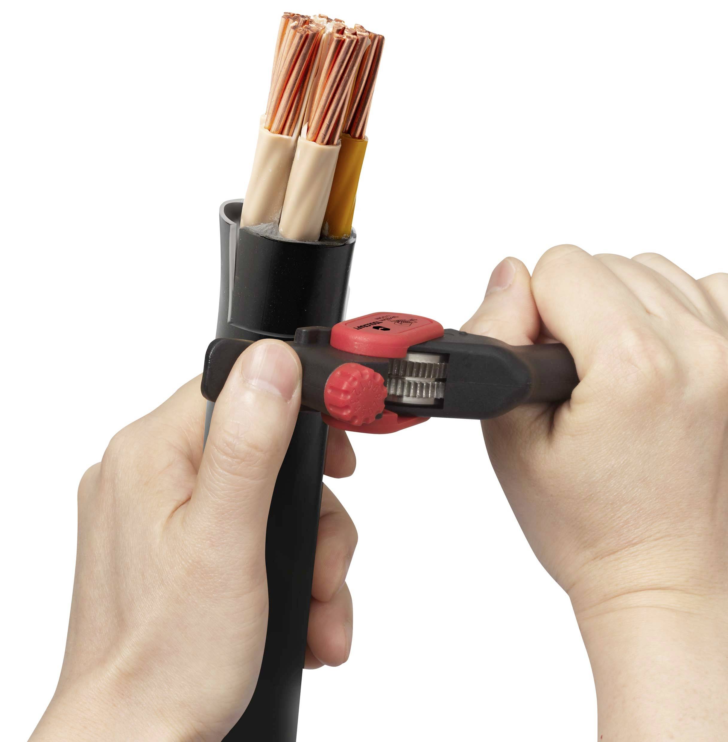 Eine Person hält ein dickes Kabel und schneidet es mit einem roten Kabelschneider. Der Kabelquerschnitt zeigt Kupferdrähte.