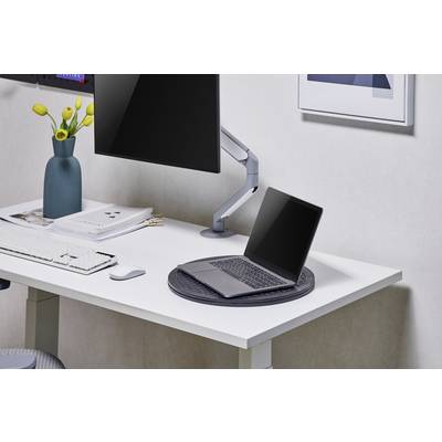 Ein Schreibtisch mit einem Laptop, einem großen Monitor, einer Tastatur und einer Vase mit gelben Tulpen in einem modernen Büro.