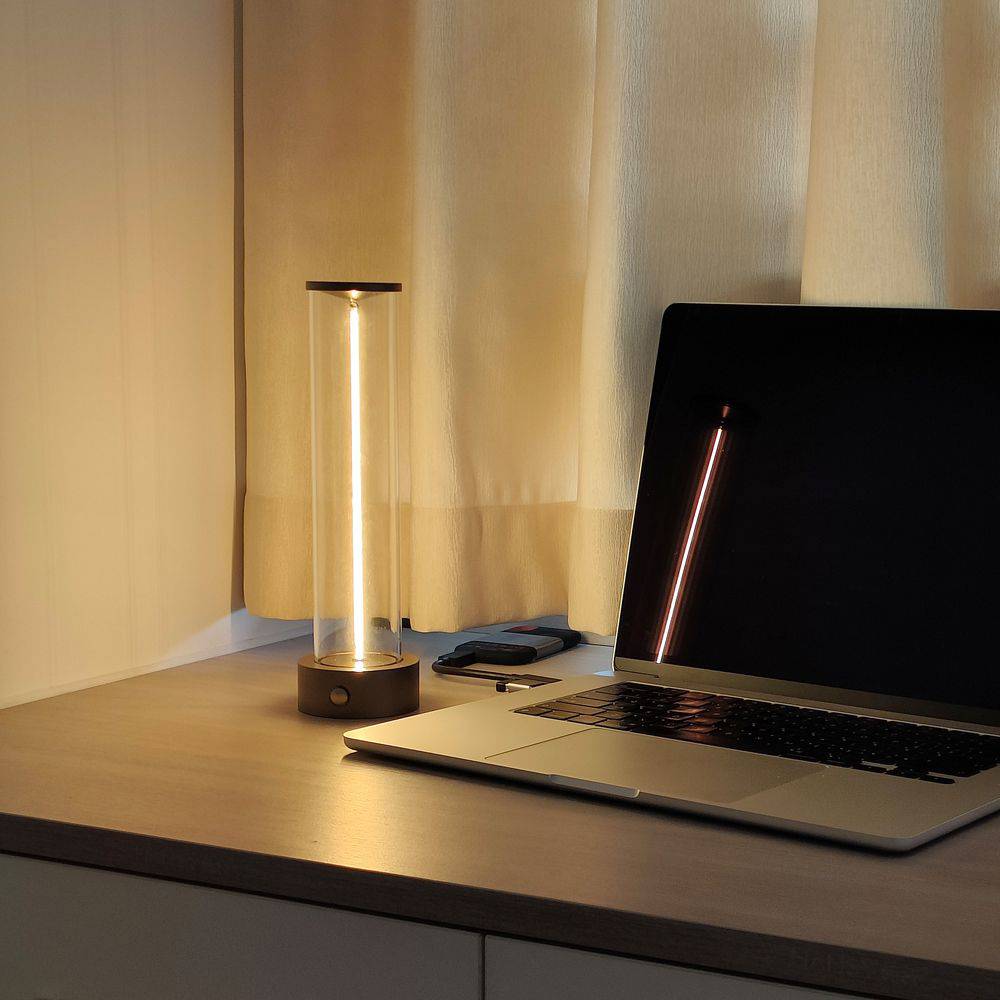 Laptop auf einem Tisch mit zwei dekorativen Lampen; das Licht schafft eine warme und gemütliche Atmosphäre im Raum.