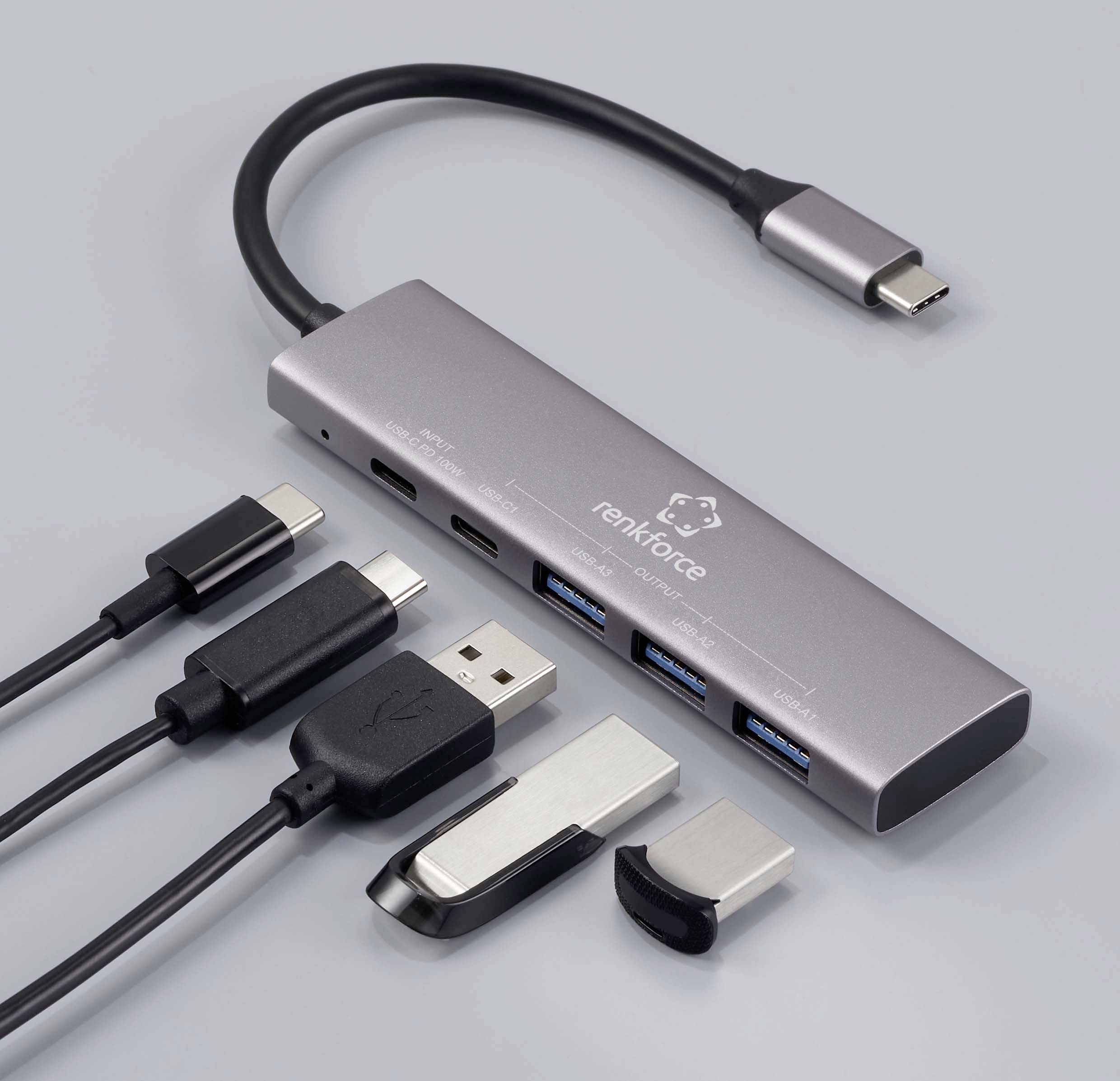 Ein USB-C-Hub mit mehreren Anschlüssen: ein USB-C, drei USB-A und zwei Speichermodule; geeignet für Datentransfer und Anschluss von Peripheriegeräten.