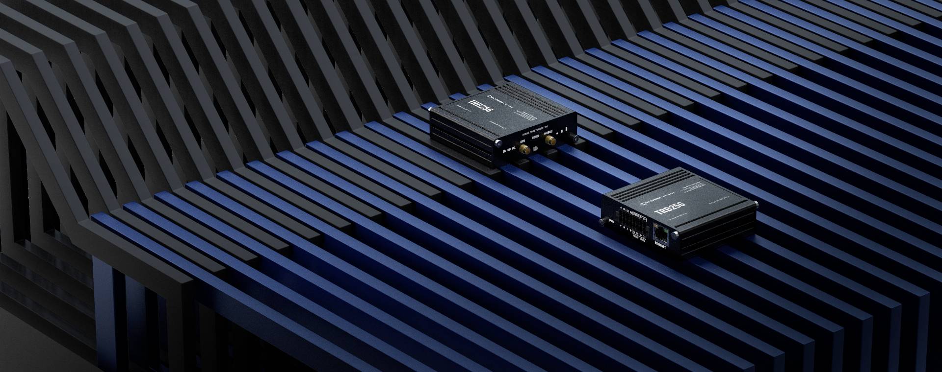 Zwei schwarze elektronische Geräte liegen auf blauen und schwarzen, parallel verlaufenden Stäben, die eine moderne, technische Atmosphäre vermitteln.