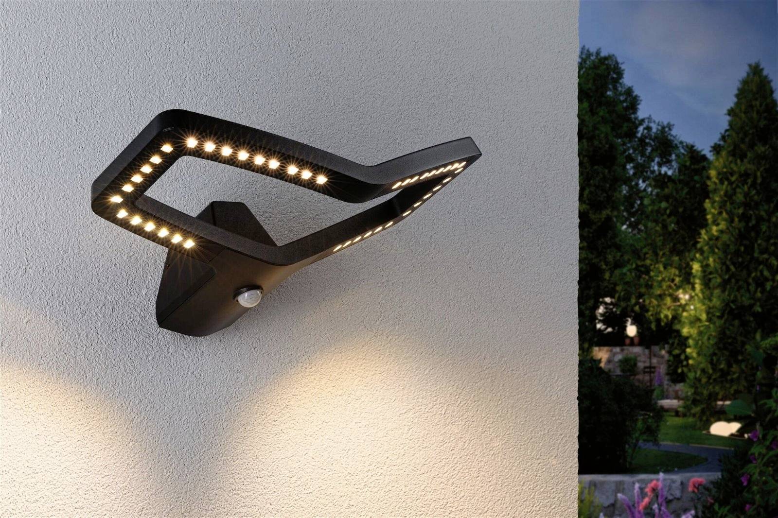 Wandleuchte mit modernem Design, beleuchtet Wand in der Dämmerung.