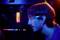Unscharfe Nahaufnahme einer Person, die auf einen Computerbildschirm schaut. Im Hintergrund leuchten RGB-Lichter im Computergehäuse.