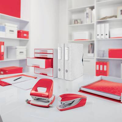 Ein moderner Büroraum mit roten und weißen Büromaterialien wie Heftgeräten, Ordnern und Notizbüchern, organisiert auf einem weißen Tisch.