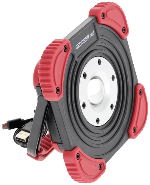 Robuster, quadratischer LED-Scheinwerfer mit rotem und schwarzem Gehäuse, Metallmittelstück und ausklappbarem Standfuß.