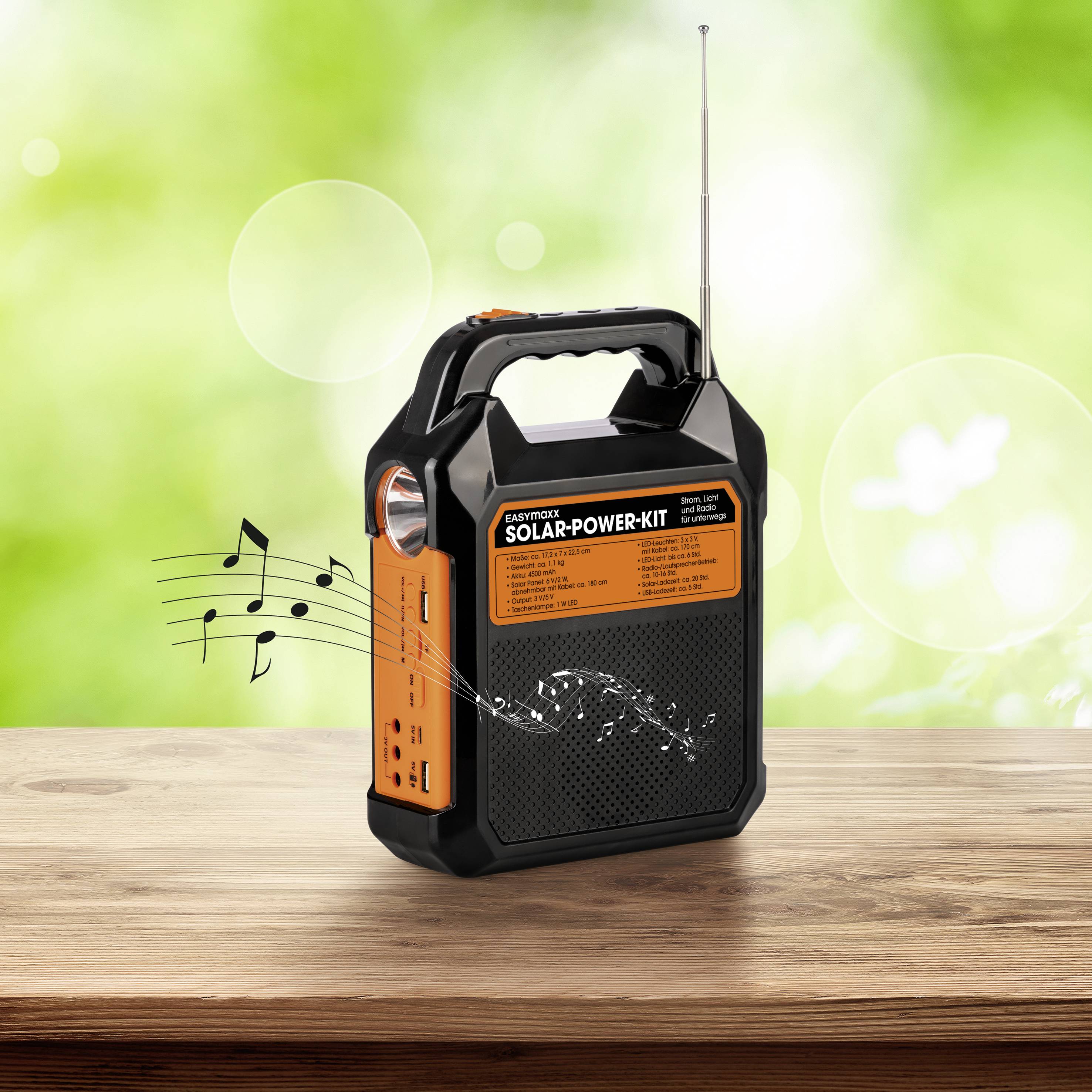 Solarbetriebenes Radio auf einem Holztisch, Musiknoten scheinen aus Lautsprechern zu kommen. Hintergrund ist grünlich verschwommen.