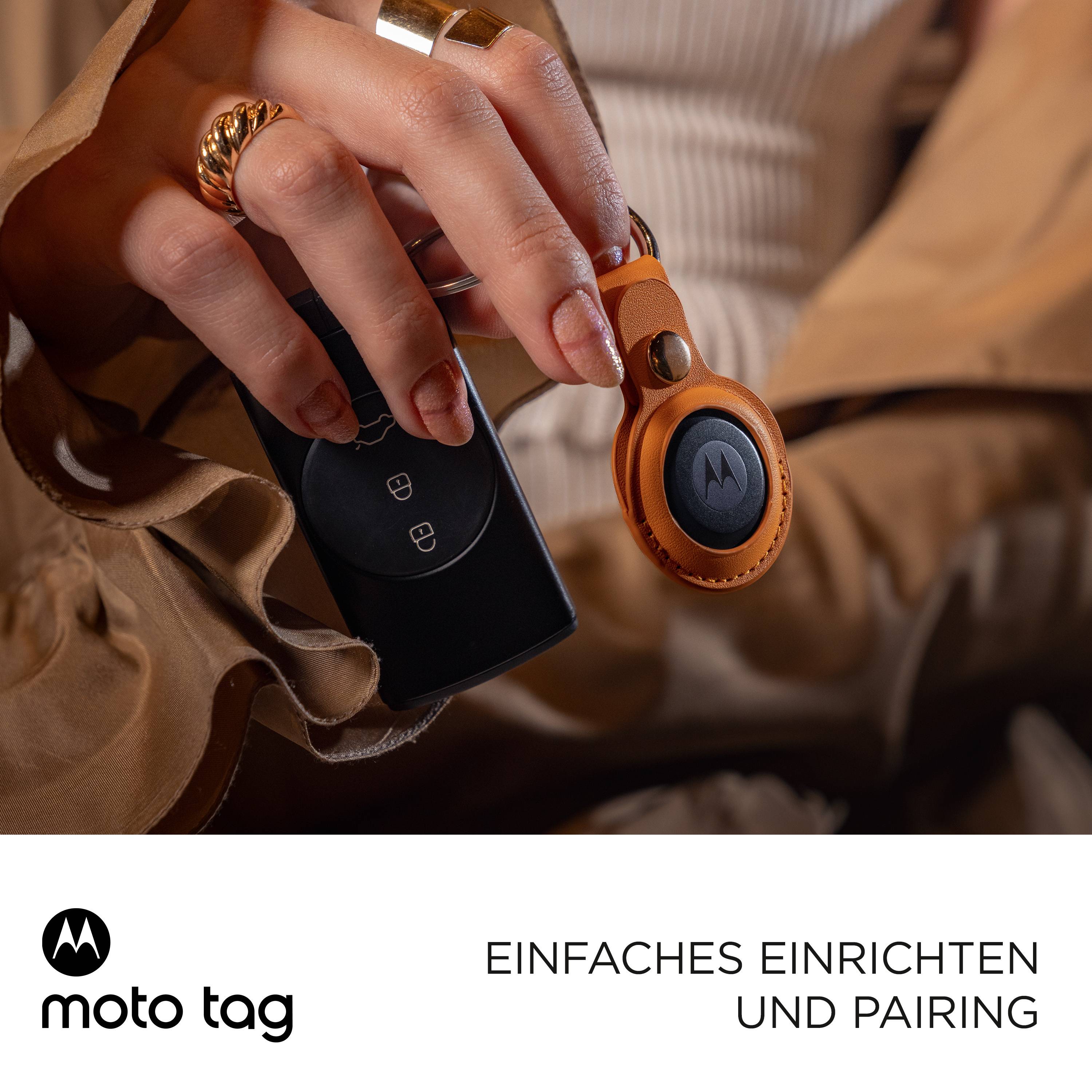 Eine Hand hält einen Schlüssel mit einem orangenen Schlüsselanhänger und einer schwarzen runden Schild mit Logo, daneben der Text 'Einfache Einrichtung und Pairing'.