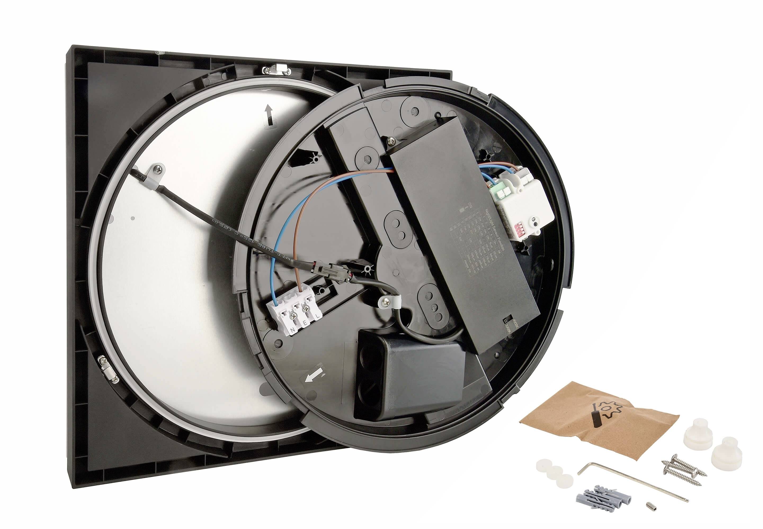 Elektrische Deckeninstallation mit geöffnetem runden Gehäuse zeigt interne Verkabelung und elektronische Komponenten, daneben Montagematerial.