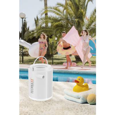 Ein weißer Lautsprecher und eine gelbe Badeente stehen am Pool. Im Hintergrund laufen drei Personen in Badebekleidung mit aufblasbaren Spielsachen.