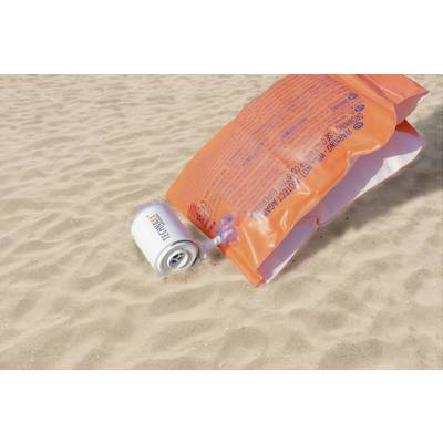 Eine orangefarbene Schwimmweste und eine Thermoskanne liegen auf sandigem Boden am Strand.