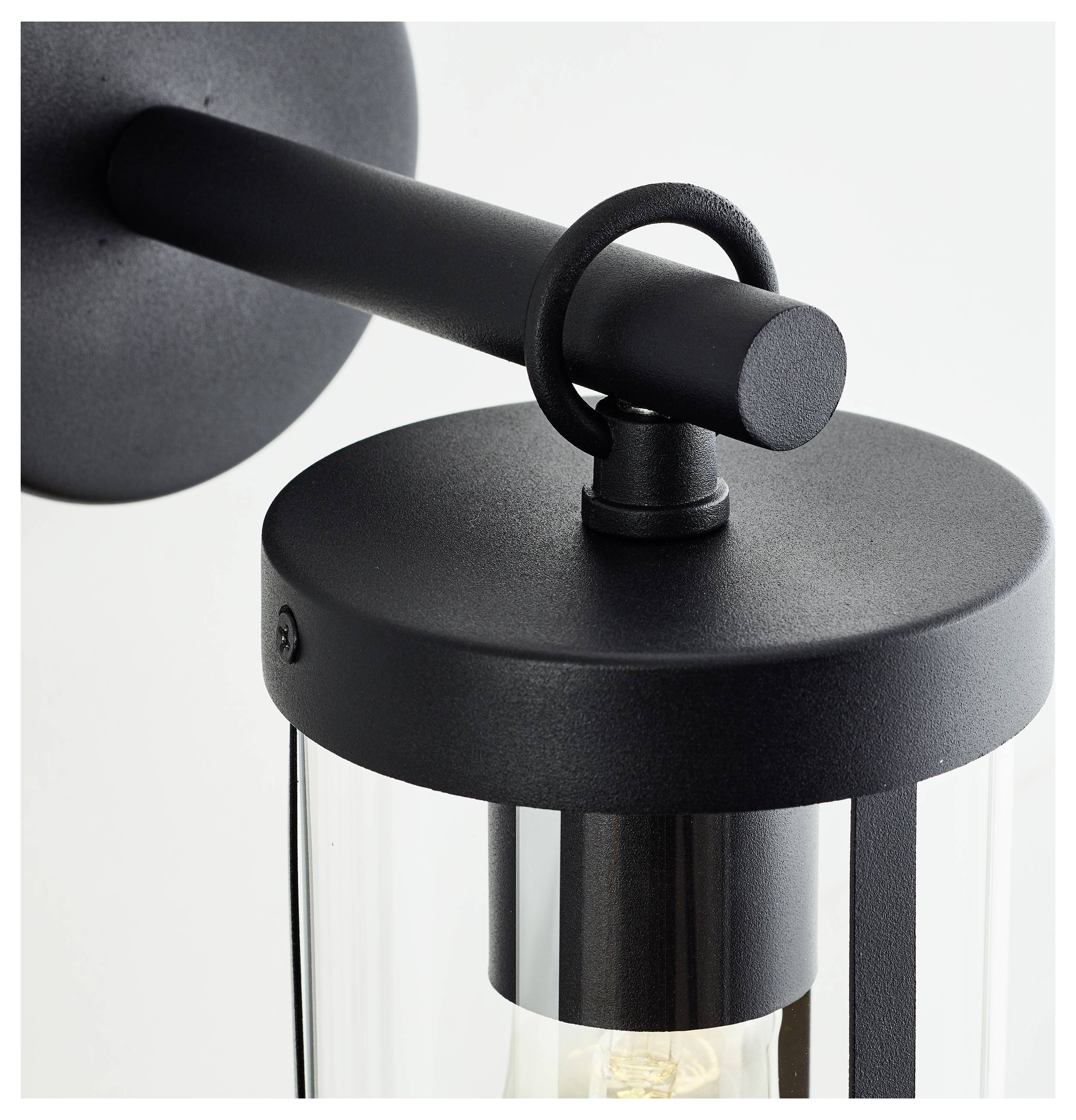 Nahaufnahme einer modernen, schwarzen Wandleuchte mit transparentem Glaszylinder und sichtbarem Leuchtmittel.