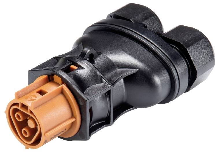 Schwarzer und orangefarbener technischer Stecker, möglicherweise für industrielle oder elektronische Anwendungen, in Nahaufnahme.
