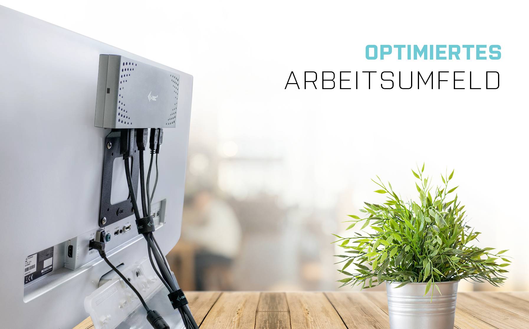 'Optimiertes Arbeitsumfeld': Monitor auf Schreibtisch mit Kabelmanagement, daneben ein grüner Pflanzentopf. Fokus auf Ordnung und Effizienz.