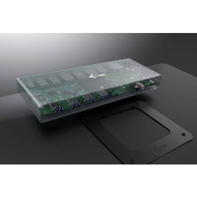 Eine durchsichtige elektronische Schaltung mit mehreren Anschlüssen und einem Logo, platziert auf einer dunklen Oberfläche.