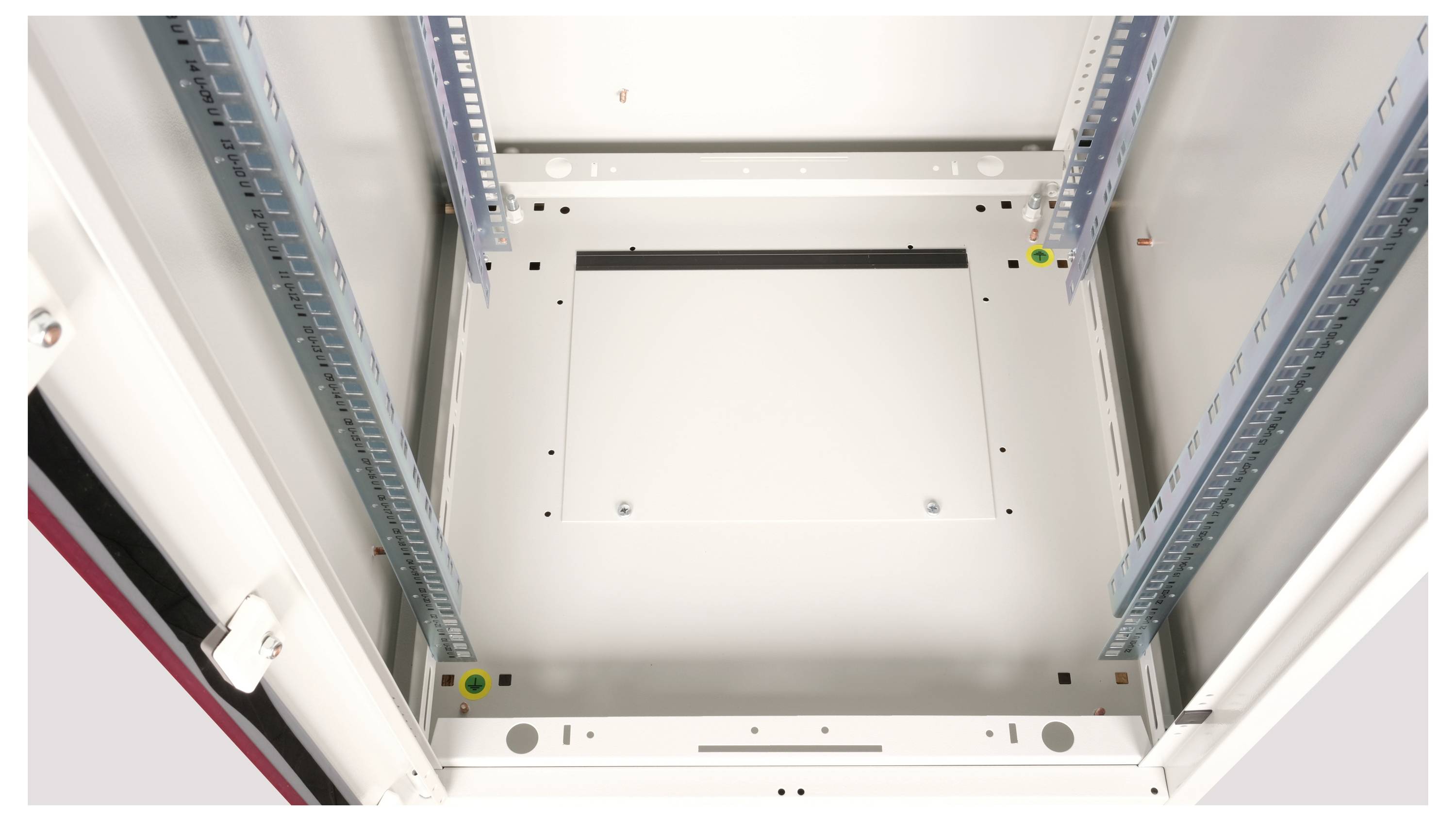 Offener Industrieraum mit Metallgestell, elektrischen Schaltkästen und Installationsschienen, geeignet für technische Geräte und Verkabelung.