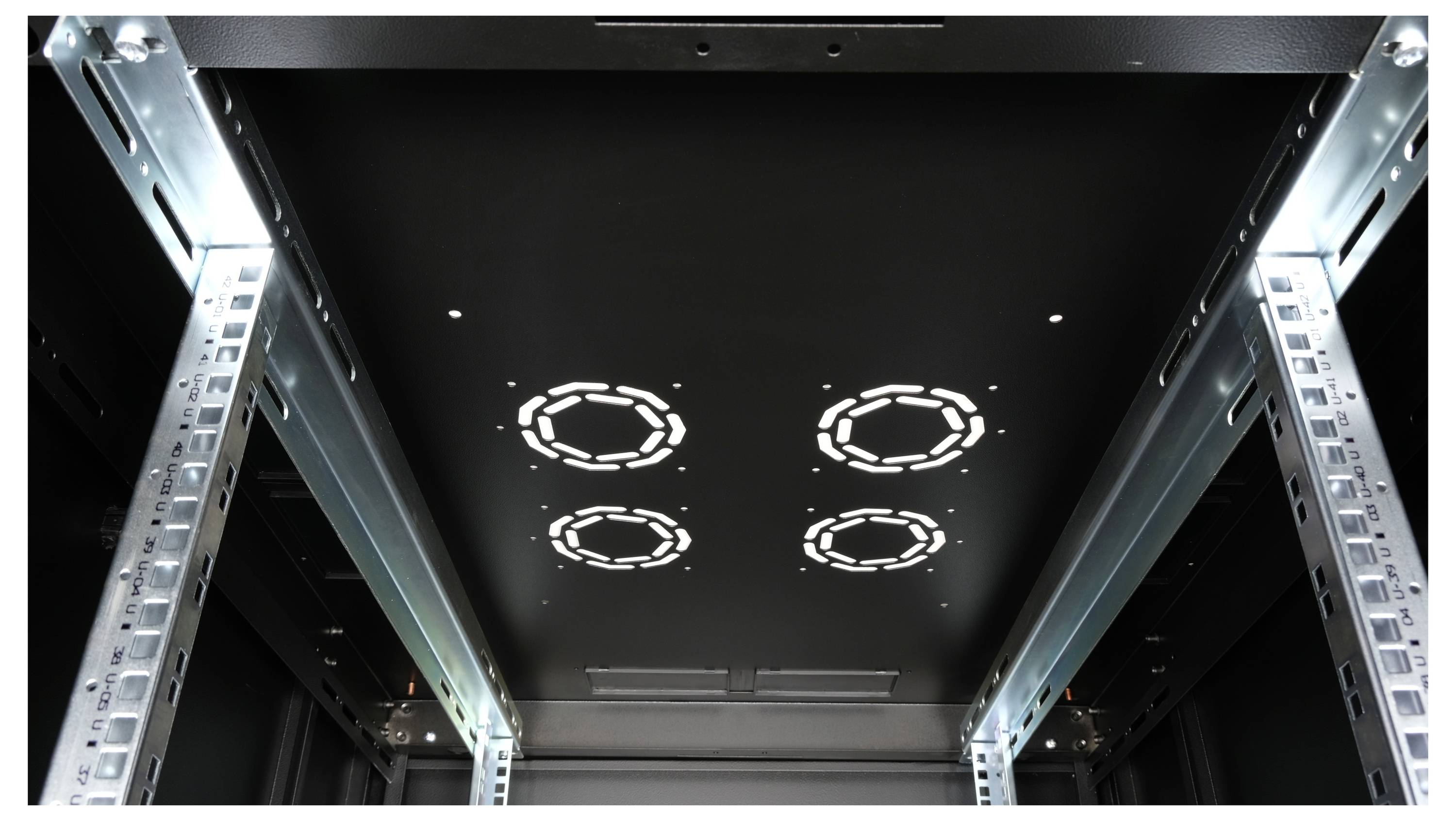 Blick in einen leeren Serverraum mit Metallschienen an den Seiten und Lichtreflexen auf der Oberseite.