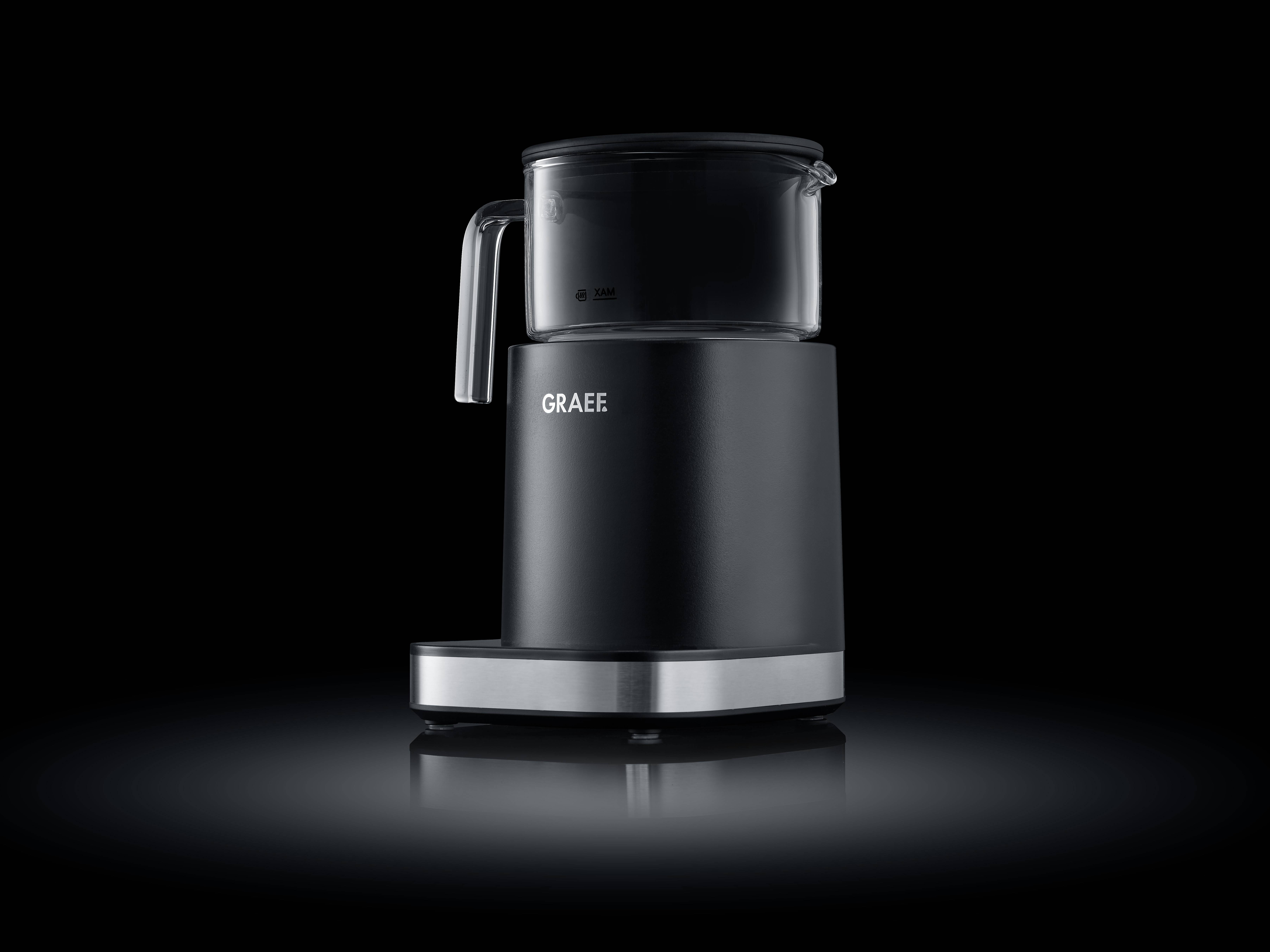 Schwarze Kaffeemaschine mit transparentem Deckel auf einem spiegelnden Untergrund, umgeben von dunklem Hintergrund.