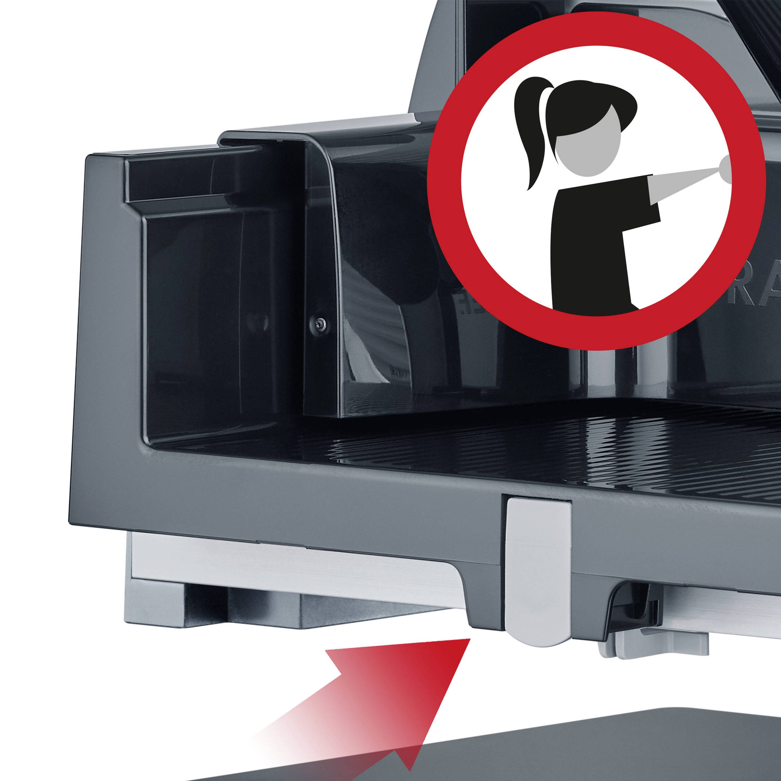 Bilderklärung: Eine Kaffeemaschine mit einem Warnschild darüber. Auf dem Schild ist ein Piktogramm einer Person, die auf etwas zeigt.