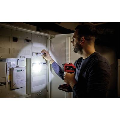 Eine Person überprüft einen Sicherungskasten mit einer Taschenlampe in der Hand.