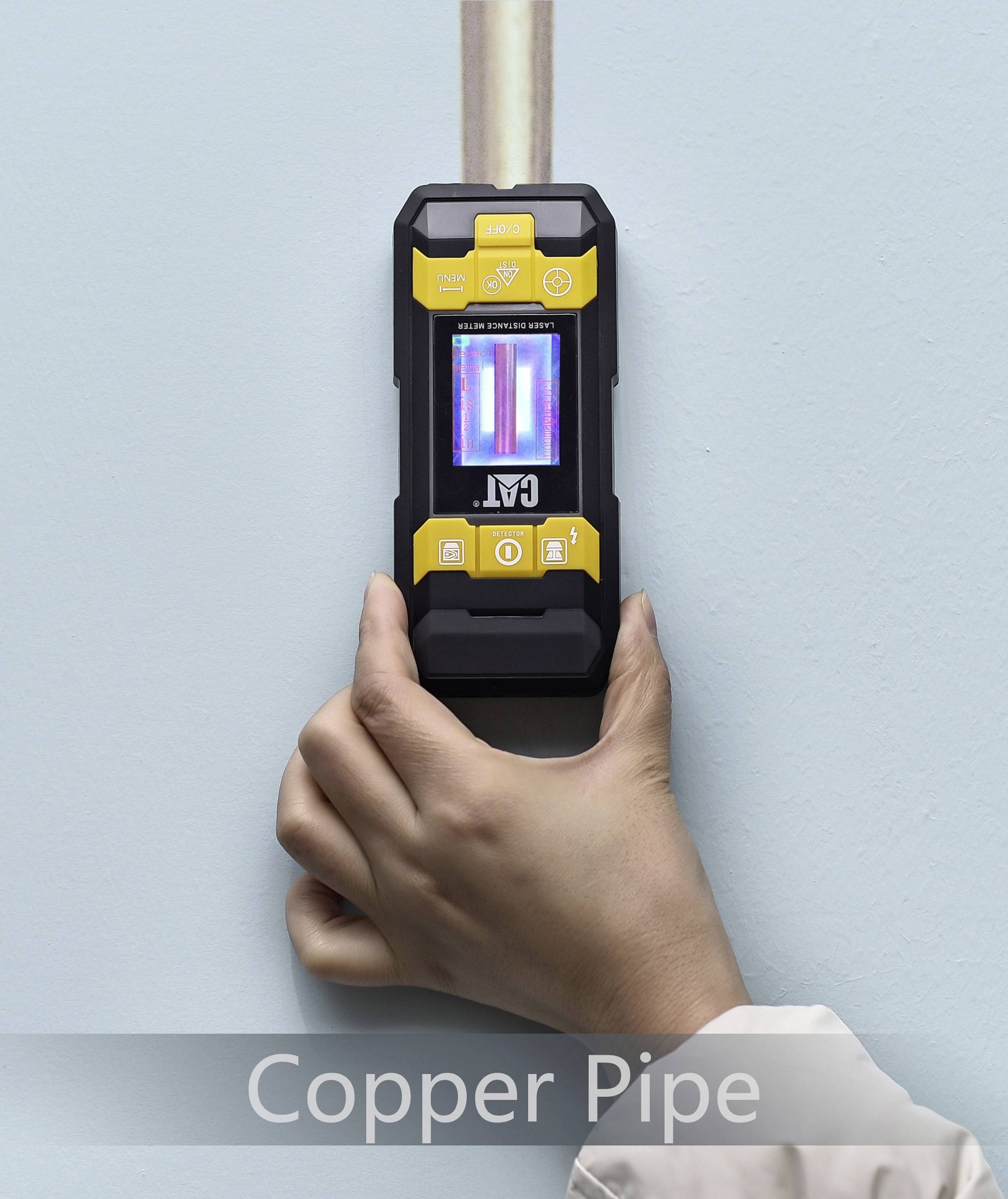 Eine Hand hält ein elektronisches Messgerät, das ein Kupferrohr in der Wand erkennt. Der Bildschirm zeigt eine Anzeige an.