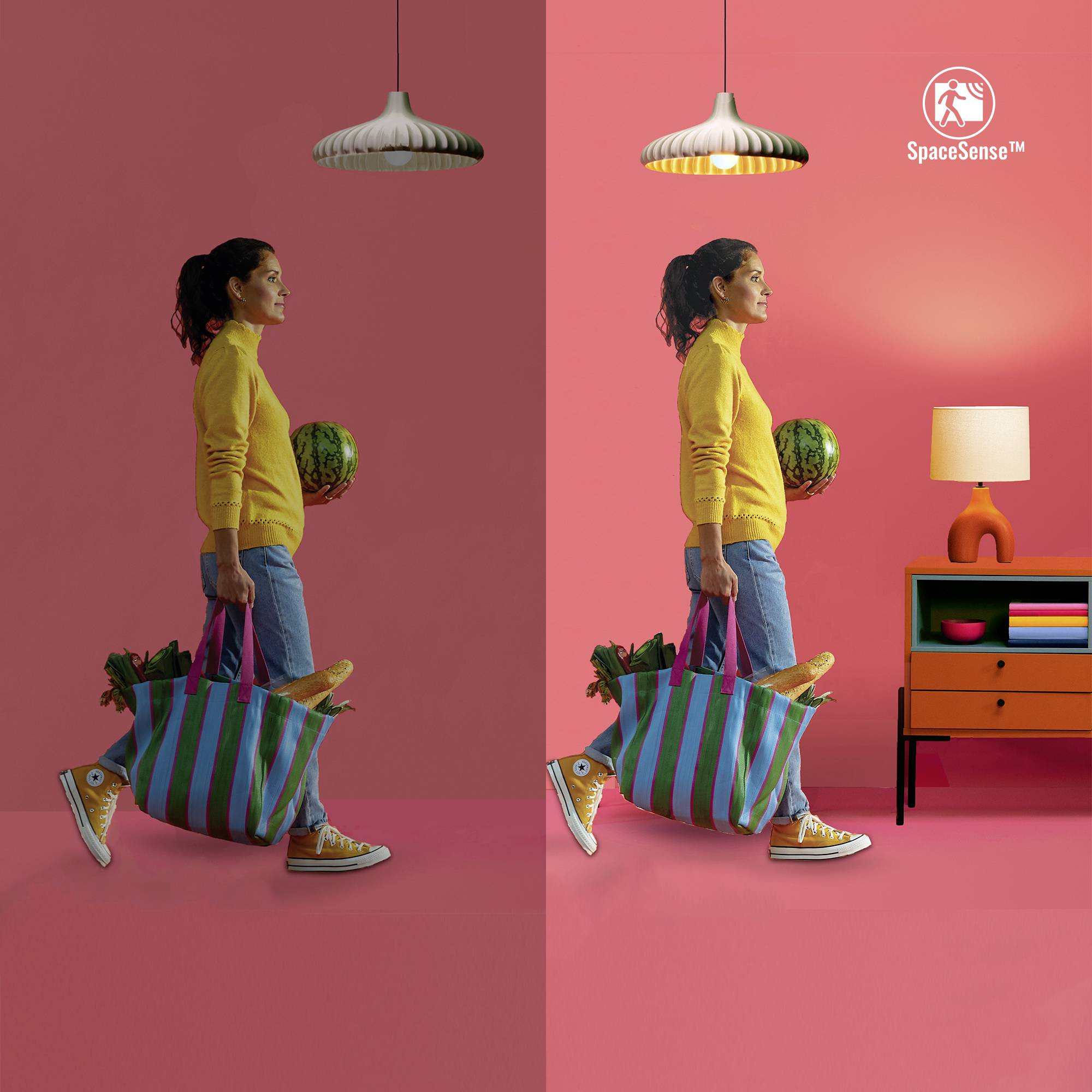 'Frau in gelbem Pullover trägt Tasche und Melone, geht vor rotem Hintergrund an Lampe und Regal vorbei; Links schummriges Licht, rechts helles Licht.'