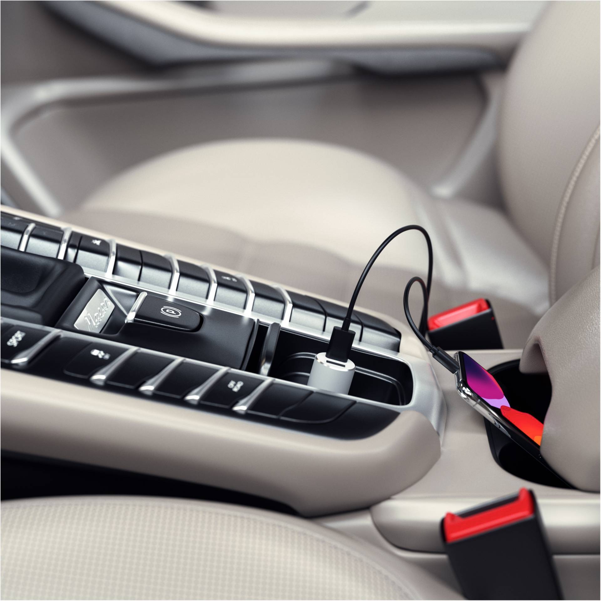 Ein Smartphone lädt in einem Auto, das Kabel ist an den USB-Anschluss in der Mittelkonsole angeschlossen.