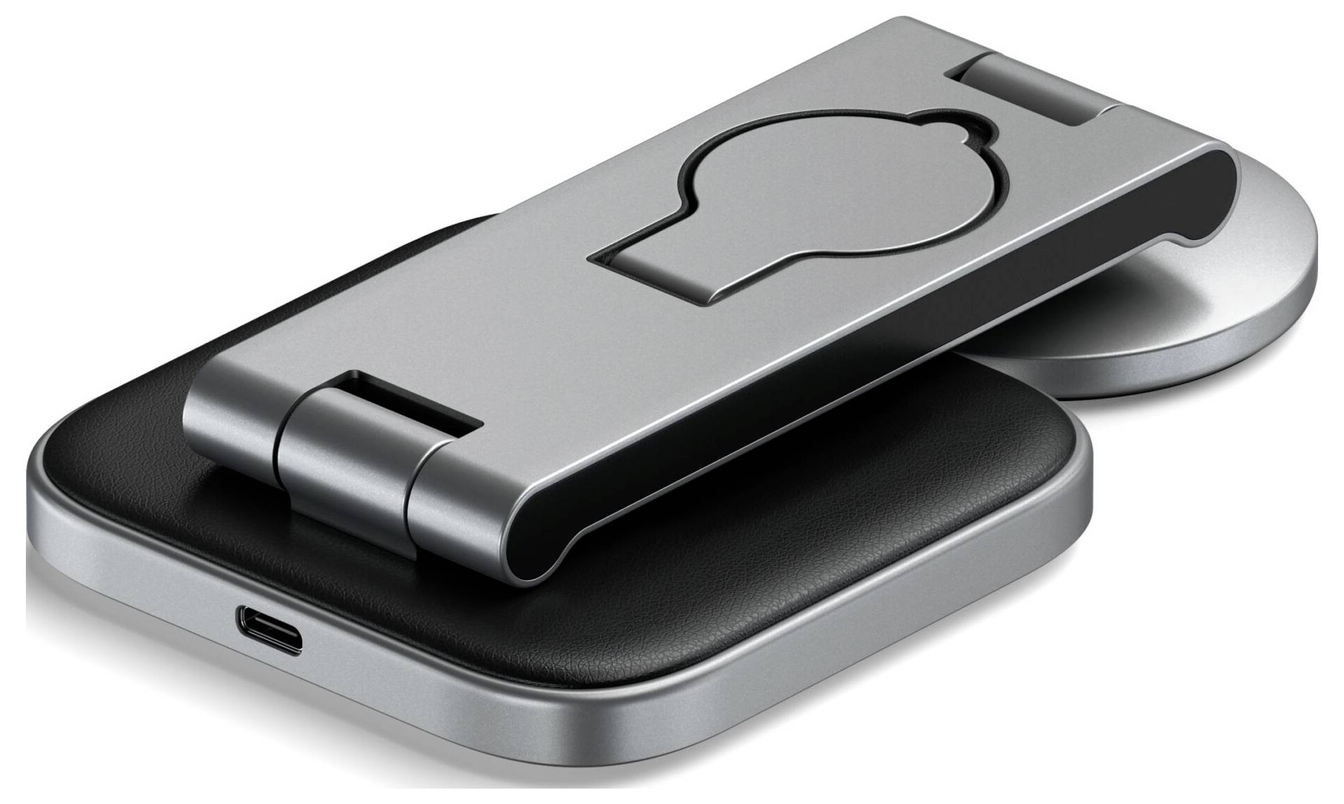 Ein silberner Handyhalter mit klappbarem Ständer und rundem Sockel. Der Sockel hat einen USB-C-Anschluss an der Seite.