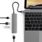 Ein Laptop mit angeschlossenem USB-Hub, zeigt verschiedene angeschlossene Adapter und Kabel auf einem Schreibtisch.