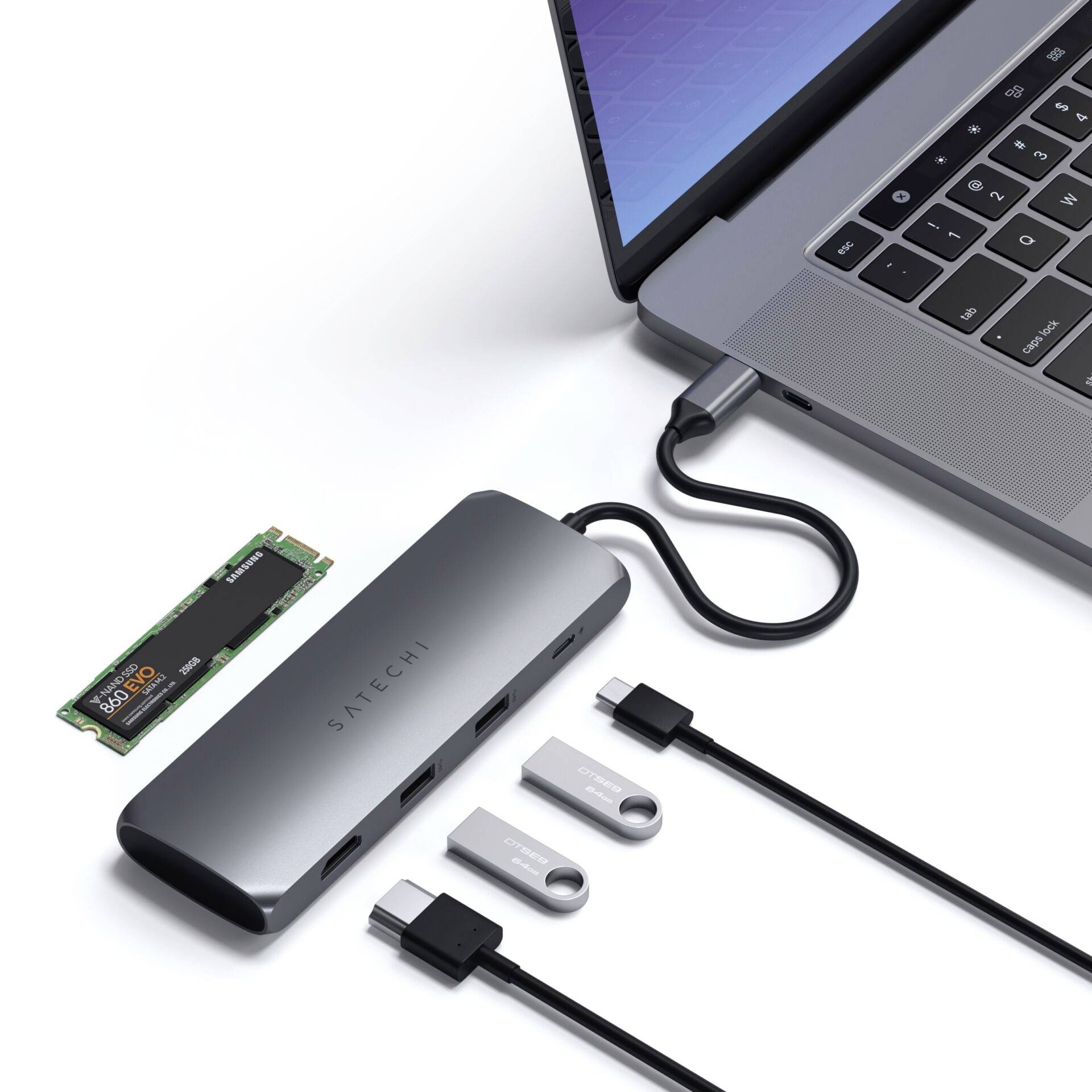 Laptop mit angeschlossenem USB-C-Hub. Der Hub verbindet ein externes Speichergerät und zwei USB-Sticks mit dem Laptop.